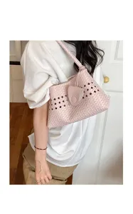 Pink woven leather underarm bag for women, stylish hollow-out design for daily commute.