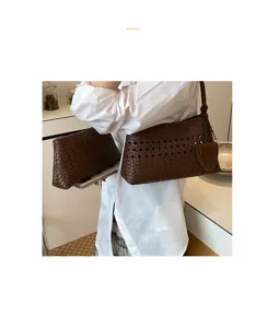 Detail shot of a stylish dark brown woven leather shoulder bag and matching pouch for women.