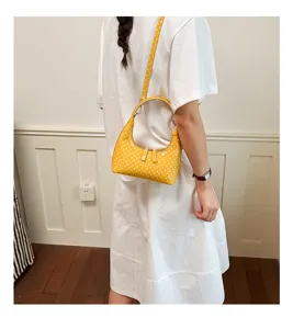 Yellow polka dot crescent shoulder bag for women, stylish minimalist crossbody handbag.
