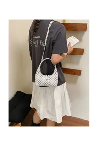 Chic white polka dot crescent shoulder bag, minimalist trendy fashion handbag for women.