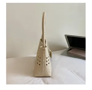 Woven leather underarm shoulder bag, elegant hollow cutout handbag for women commuting.