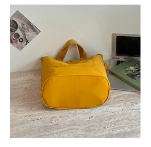Détail de sac seau en toile jaune décontracté coréen, montrant le tissu et la poche avant.