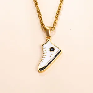 Detail shot of a minimalist gold stainless steel necklace featuring a miniature white sneaker pendant.