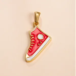 Close-up detail of red enamel high-top sneaker pendant, gold plated metal accessory.