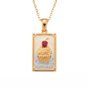 Detailed view of the gold-plated tarot card necklace featuring a cute cupcake design with red crystal.