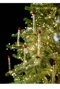 Detailansicht von Champagner Glas Kerzen Ornamenten an einem glitzernden Weihnachtsbaum.