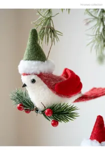 Detailed shot of cute felt Christmas bird ornament with mini santa hat, pine needles, red berries.