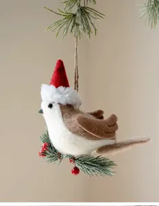 Detailed close-up of a cute felt Christmas bird ornament with a Santa hat and pine branch.