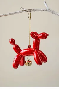 Detailed close-up shot of the red balloon dog pendant, hanging on a branch with a gold bell.