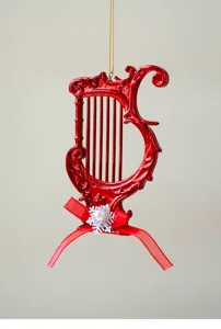 Red harp Christmas ornament detail view, glossy finish with ribbon bow for holiday tree decor.
