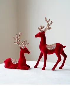 Detailed close-up of red flocked Christmas deer figurines with sparkling sequin antlers for decor.
