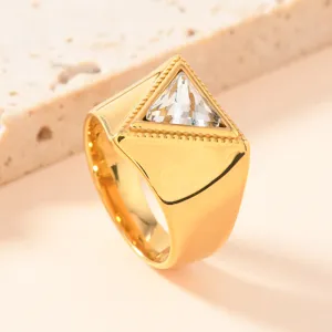 Detailaufnahme eines modernen goldenen Titanstahlrings mit einem stilvollen dreieckigen Kristall.