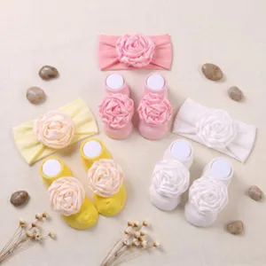 Dettaglio del set fascia con fiori e calzini antiscivolo per bambina, grazioso accessorio.