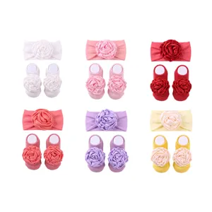 Vista dettagliata del set di fascia e calzini da neonato con raffinato design di rose.