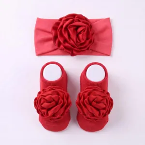 Primo piano dettagliato del set di fascia e calzini per neonati con rosa rossa, dettaglio.