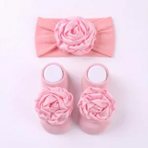 Set fascia e calzini rosa per neonata, tessuto in maglia morbida per dettagli da bambina.