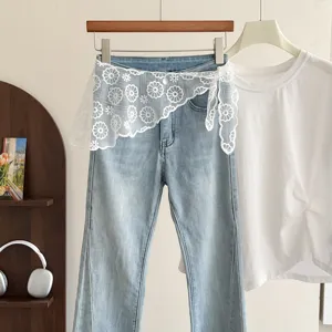 Sweet lace waist wrap mesh skirt overlay with light blue jeans, stylish women's apparel detail.