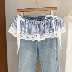 Detailed view of the blue checkered lace ruffled denim skirt extension with side ribbon ties.