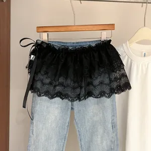 Jeans de moda para mujer con superposición de falda de encaje negro y lazo chic.
