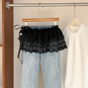 Vaqueros azul claro de moda con falda de encaje negro y lazo de cinta en el lateral.
