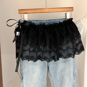 Vaqueros de mezclilla clara con sobrefalda de encaje negro y elegante lazo lateral