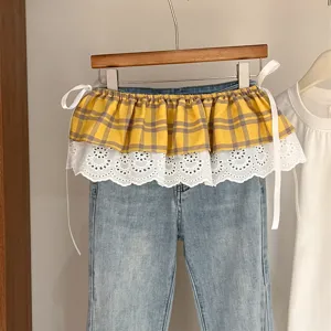 Detailed close-up of the Korean style layered fake two-piece yellow plaid and white lace waist skirt.