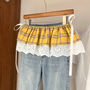 Plaid and white lace layered skirt extension detail, stylish detachable waist accessory.