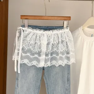 Vista detallada de vaqueros elegantes con elegante volante de encaje blanco y lazos laterales.