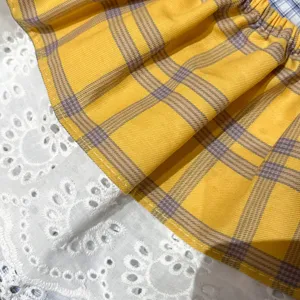 Women plaid lace layering skirt detail view, cute yellow plaid fabric and white eyelet lace trim.