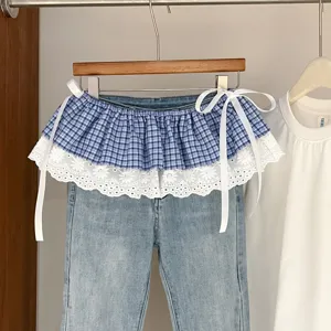 Stylish women layered denim pants with blue plaid lace waist wrap skirt, spring summer fashion.