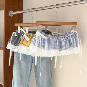 Detailed view of layered plaid lace skirt extender with cute tie straps and white trim.
