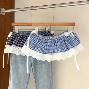 Detail shot of plaid lace waist extender skirt with bow tie, retro layered fake hem design.
