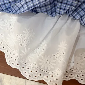 Detailed shot of Korean style plaid layering skirt with white floral lace embroidery hem.