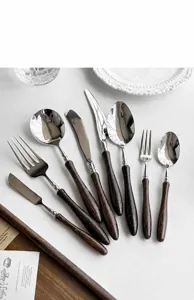 Set di posate in acciaio inossidabile con manico in legno, cucchiaio, forchetta e coltello.