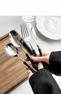 Set di posate in acciaio inossidabile con manico in legno, vista dettagliata forchetta e coltello.