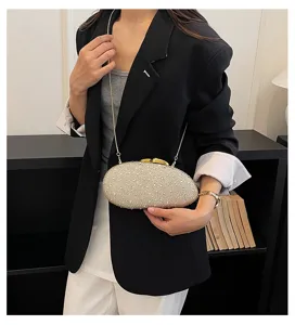 Sac de soirée strassé avec chaîne, design ovale élégant idéal pour fêtes et événements.