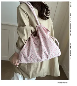 Detalle de bolso bandolera de pana rosa, lindo estampado de estrellas y estilo casual.