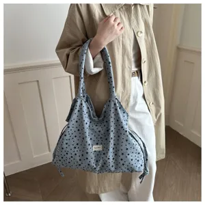 Vista detallada del bolso tote azul casual con estampado de estrellas y correas suaves.