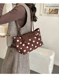 Detailed view of a brown polka dot shoulder bag with dual straps and flap closure.
