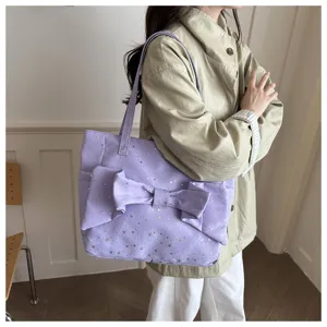 Vista dettagliata della borsa tote viola chiaro con grande fiocco e motivi di stelle.
