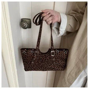 Nahaufnahme einer modischen Leo-Schultertasche mit Metallösen und dekorativen Schnallen.