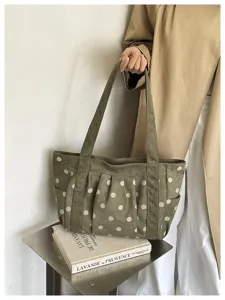 Vista dettagliata della borsa tote rétro verde a pois, con grande capacità e spallacci comodi.