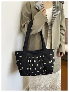Vista dettagliata della borsa shopper in tela nera a pois bianchi, uso quotidiano e capiente.
