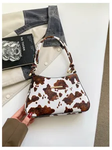 Borsa a spalla ascellare in pelle stampa mucca marrone bianco, dettaglio borsa elegante.