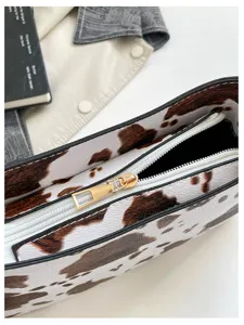 Dettaglio borsa a tracolla in pelle stampa mucca, borsa vintage elegante donna.