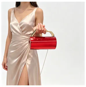 Glanzende rode metalen cilinder clutch, gouden geometrisch handvat, elegant avondaccessoire.