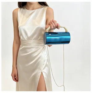 Metalen blauwe cilindrische clutch tas met gouden handvat en ketting voor avondfeest.