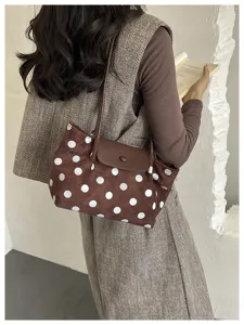 Detail shot of the brown polka dot shoulder bag, highlighting fabric texture and flap closure.