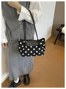 Stylish black polka dot shoulder bag with leather flap and strap for daily commuting.