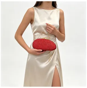 Vue détaillée d'un sac de soirée rouge en cristal avec strass scintillants et chaîne dorée.